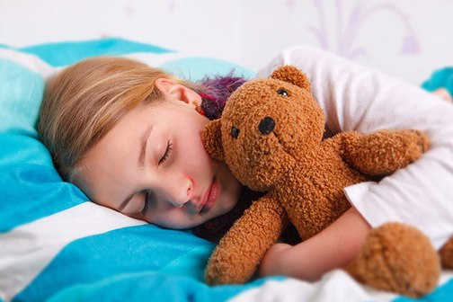 Child sleeping with soft toy 