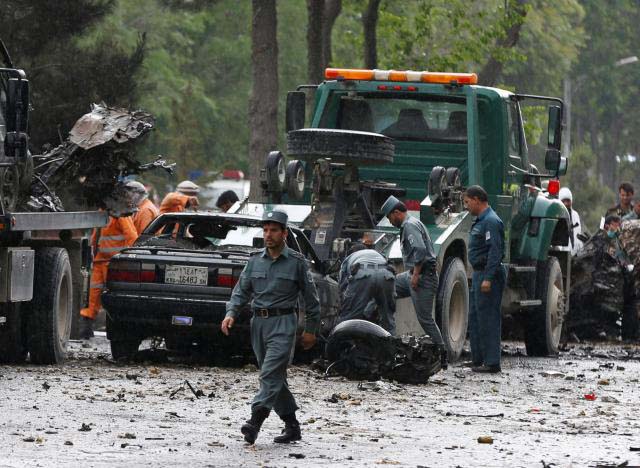  Afghan policemen inspect the site of a suicide attack in Kabul.