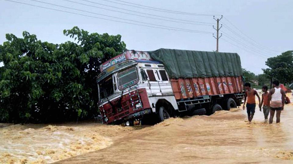 A truck drifts off the submerged NH 28 at flooded Ramgadhwa in East Champaran