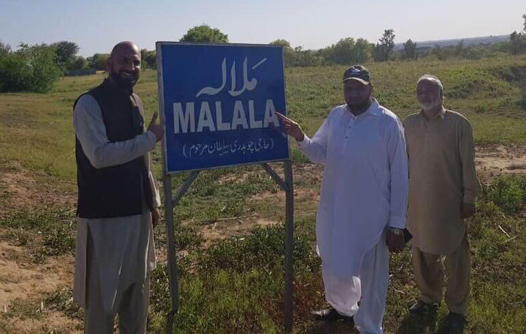 Rawalpindi Villager standing and pointing towards the board 