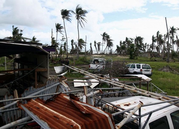 Abandoned cars are seen near a damaged building after Hurricane Maria hit the island