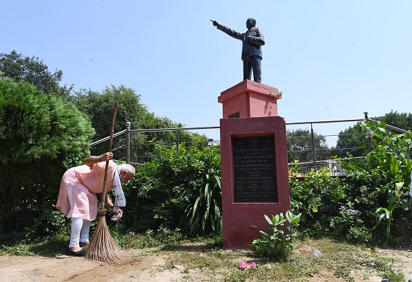 Prime Minister Narendra Modi sweeping and cleaning the premises of Baba Sahib Ambedkar Higher Secondary School