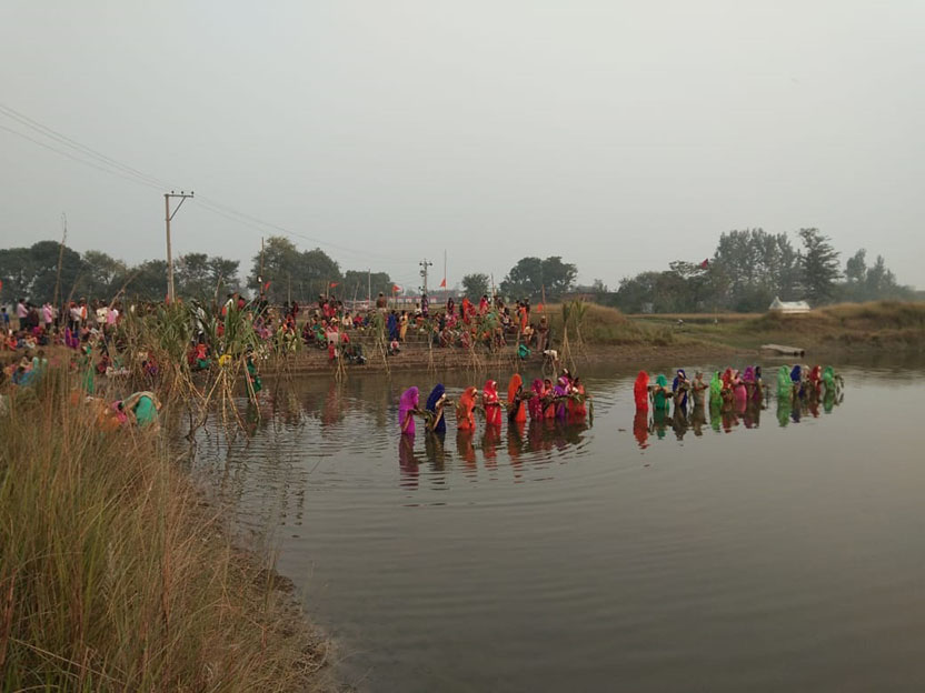 उगते सूर्य को अर्घ्य देती व्रती महिलायें