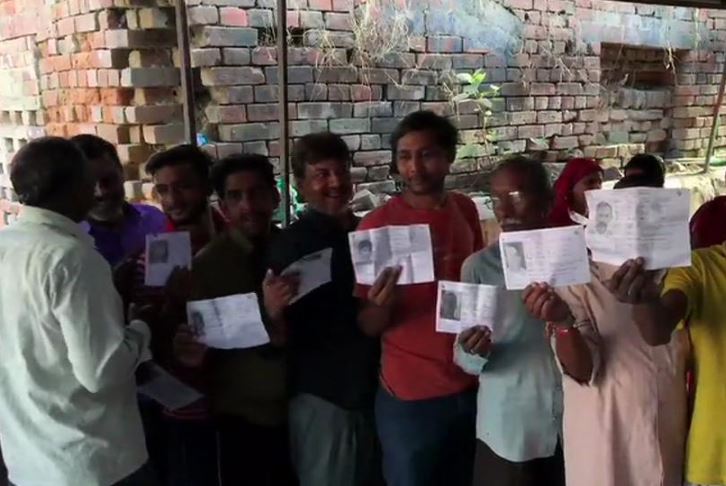 Voters queue up outside a polling station in Ayodhya