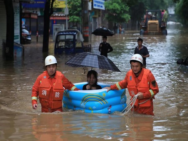 A woman being rescued by emergency workers in China’s Jiangxi province