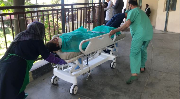 Hospital employees transport a wounded woman after a blast in Kabul, Afghanistan