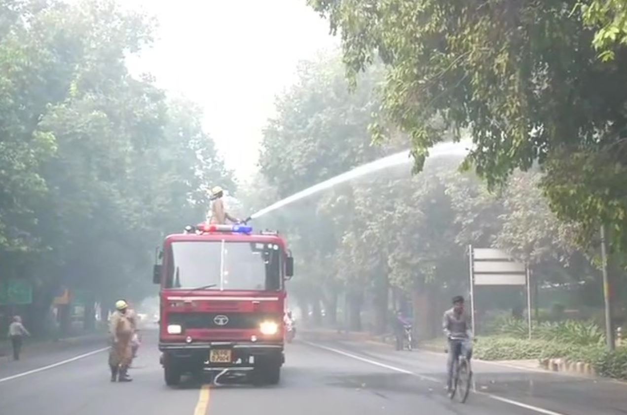 NDMC sprinkles water in the area around Feroz Shah Road to settle the dust, as a pollution control measure