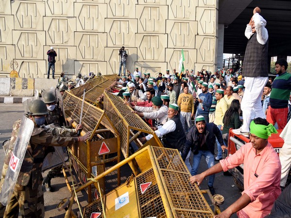 Members of Bhartiya Kisan Union try to remove the barricades as they protest at the Delhi-Gaziabad border, in New Delhi on Sunday.