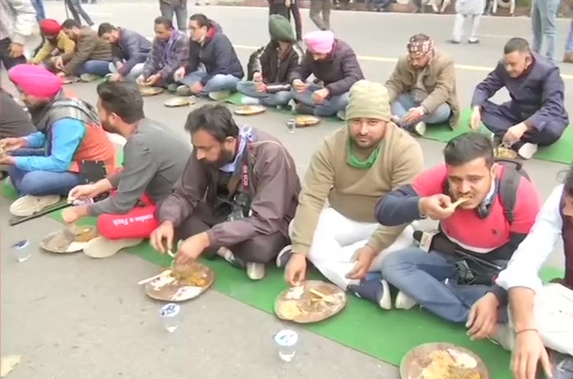 सरकार और किसानों की वार्ता के बीच विज्ञान भवन के बाहर लगाये लंगर में भोजन करते किसान