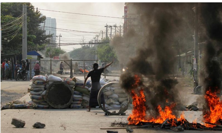 A demonstrator gestures near a barricade during a protest against the military coup in Mandalay