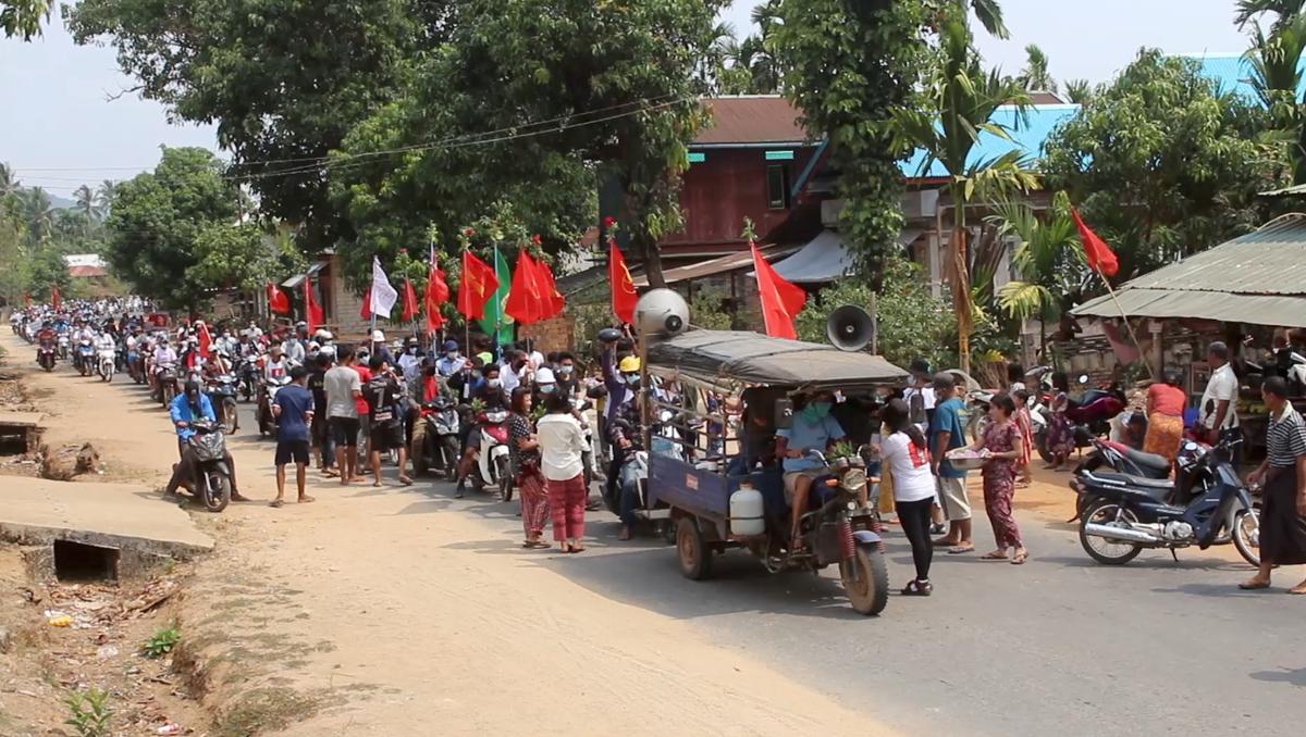 Demonstrators hold flags as they sit on motorcycles during a protest in Launglone, Dawei district