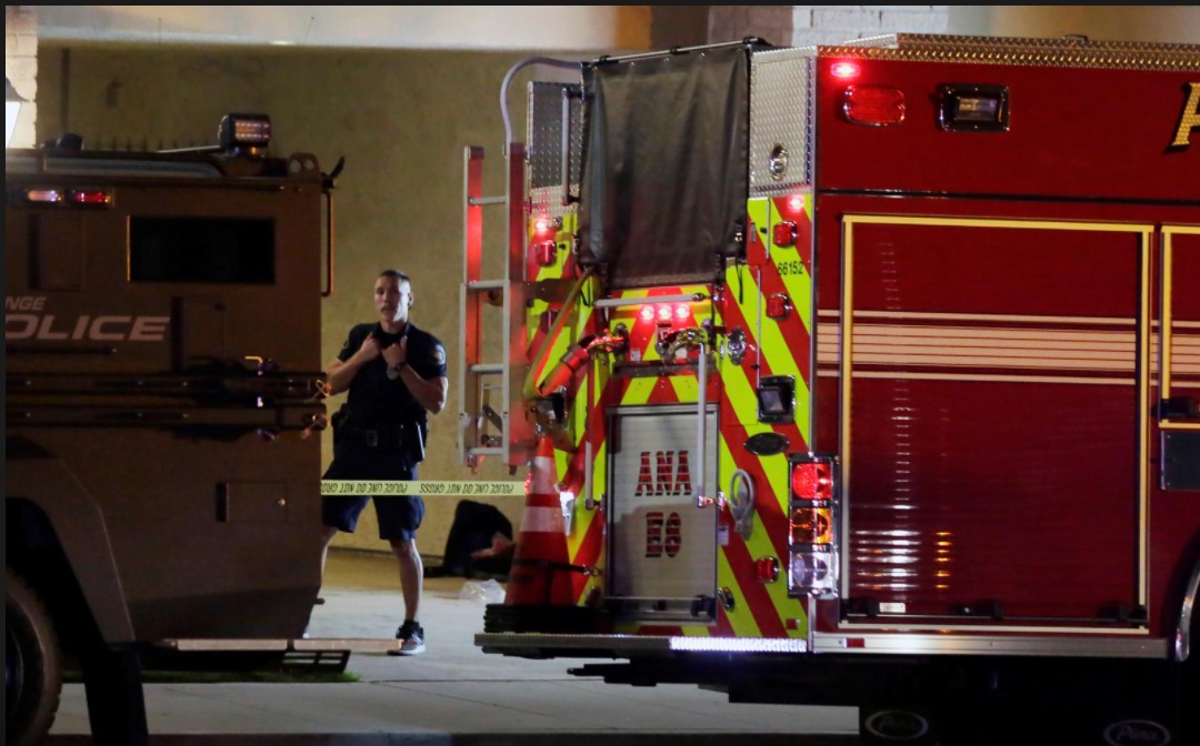 A police officer stands in front of a building after a shooting at an office building in Orange, California