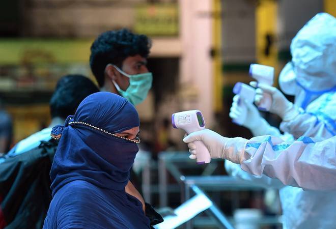 People getting temperature check before entering railway station