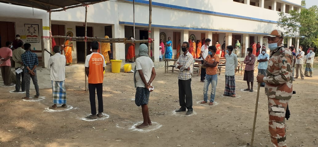 People queue up at their respective polling booths as voting