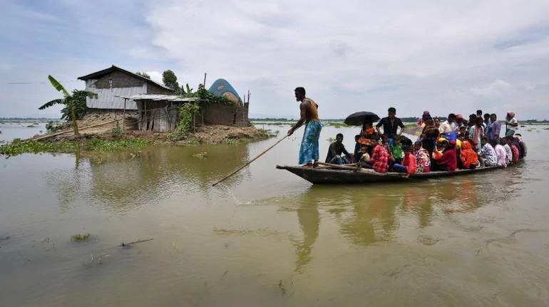 बाढ के खतरे के मद्देनजर सुरक्षित स्थान पर जाते लोग