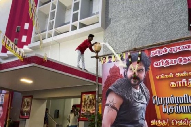 A fan offering milk at  'Ponniyin Selvan' poster