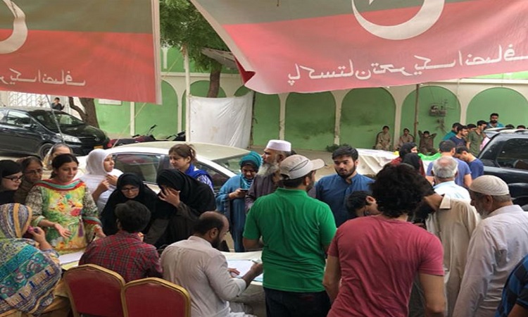 Voters queue up at a PTI bench near the voting centre